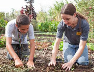FoodCorps Hawai‘i service member Julia Nemoto works with a student at Māla‘ai: The Culinary Garden of Waimea Middle School.