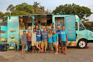 Members of The Kohala Center’s staff and ReefTeach volunteers pose in front of the new center at Kahalu‘u Beach Park.