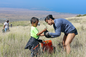A mother and her young son plant a native koai‘a tree in the Pelekāne Bay watershed on Earth Day 2017